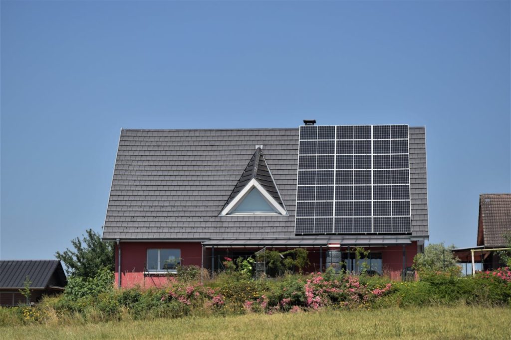 pexels-photo-17361836 A modern house with solar panels and a garden, showcasing sustainability.